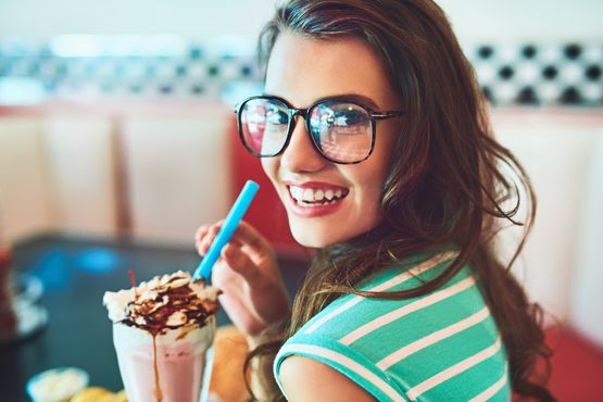 chica con helado en copa sonrie a camara